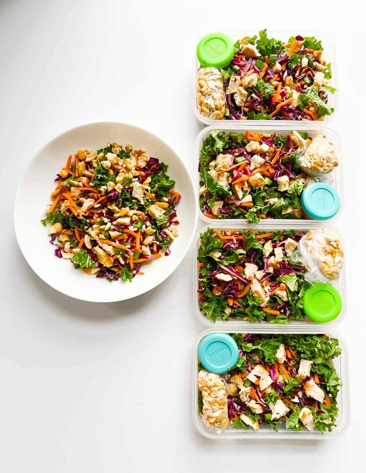 chicken salad in white bowl with four chicken salads in containers to its right.