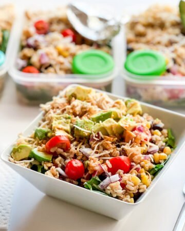 Southwest Chipotle-Lime Chicken Salad in a bowl with meal prep containers in background.