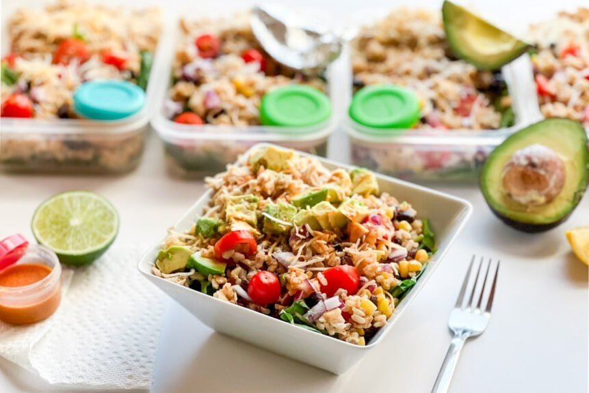 Southwest Chipotle-Lime Chicken Salad in a bowl with meal prep containers in background.