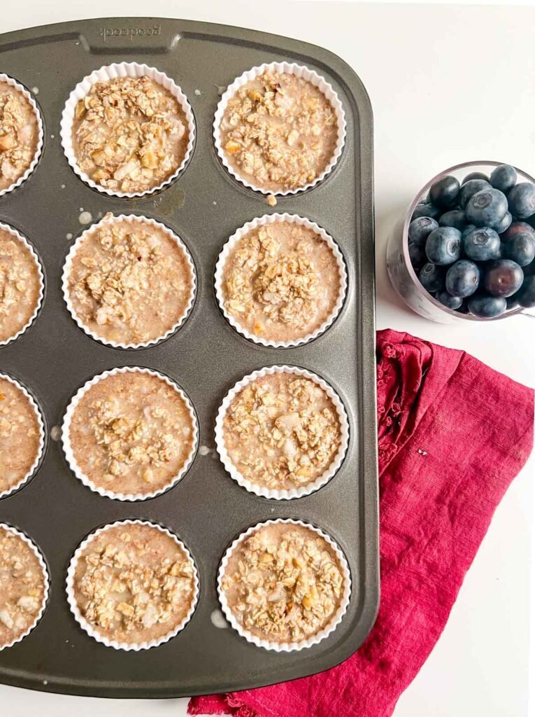 oatmeal batter in tins with blueberries on side