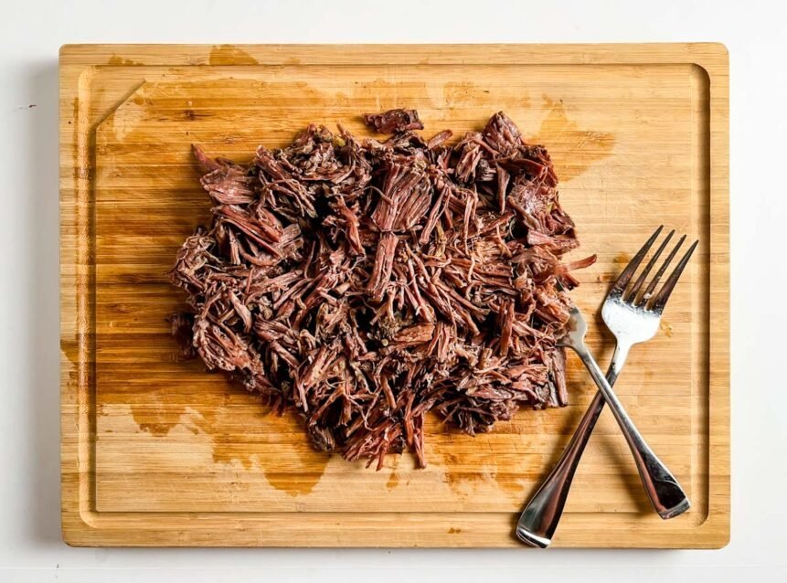 shredded beef on cutting board